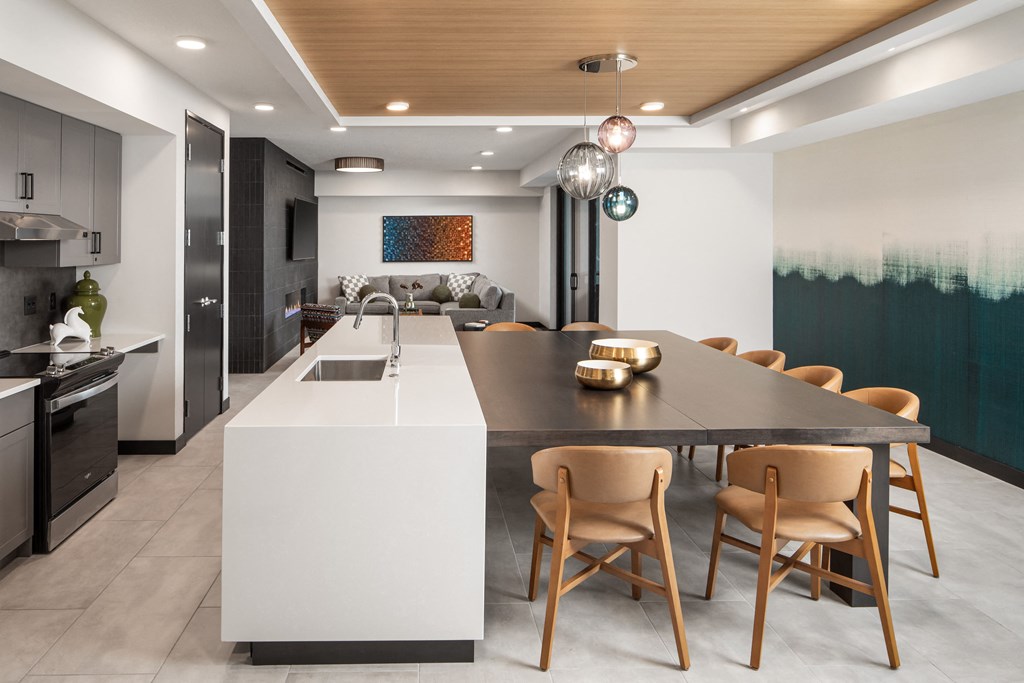 a kitchen with a large island and a dining table with chairs