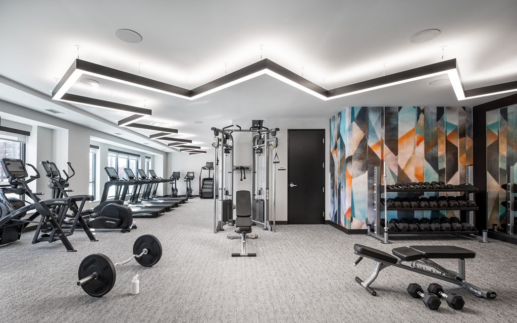 a gym with weights and other exercise equipment and a colorful wall