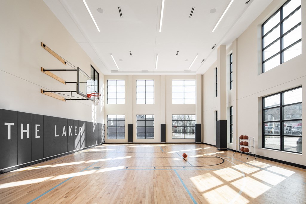 the large gym has a hardwood floor and large windows