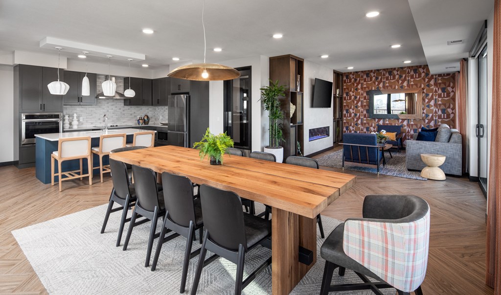 a dining room and kitchen with a wooden table and chairs