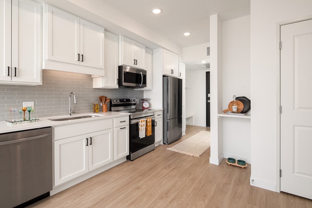 a renovated kitchen with white cabinets and stainless steel appliances