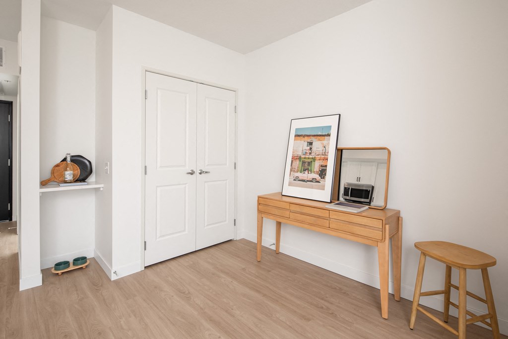 a living room with a desk with a computer and a mirror