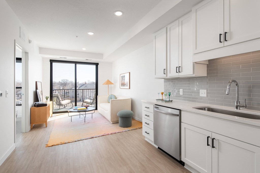 an open living room with a kitchen and a sliding glass door