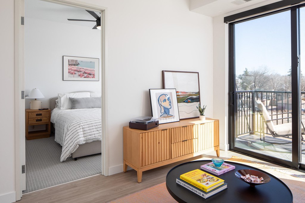 a bedroom with a large window and a table with books on it