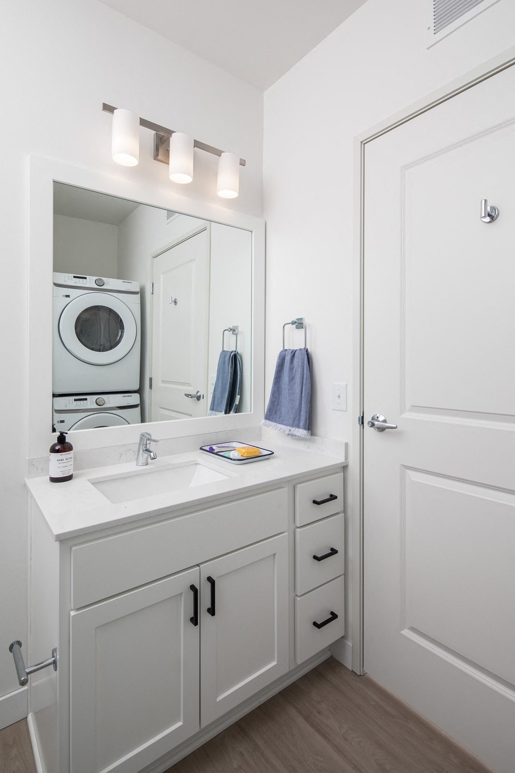a white bathroom with a sink and a washing machine