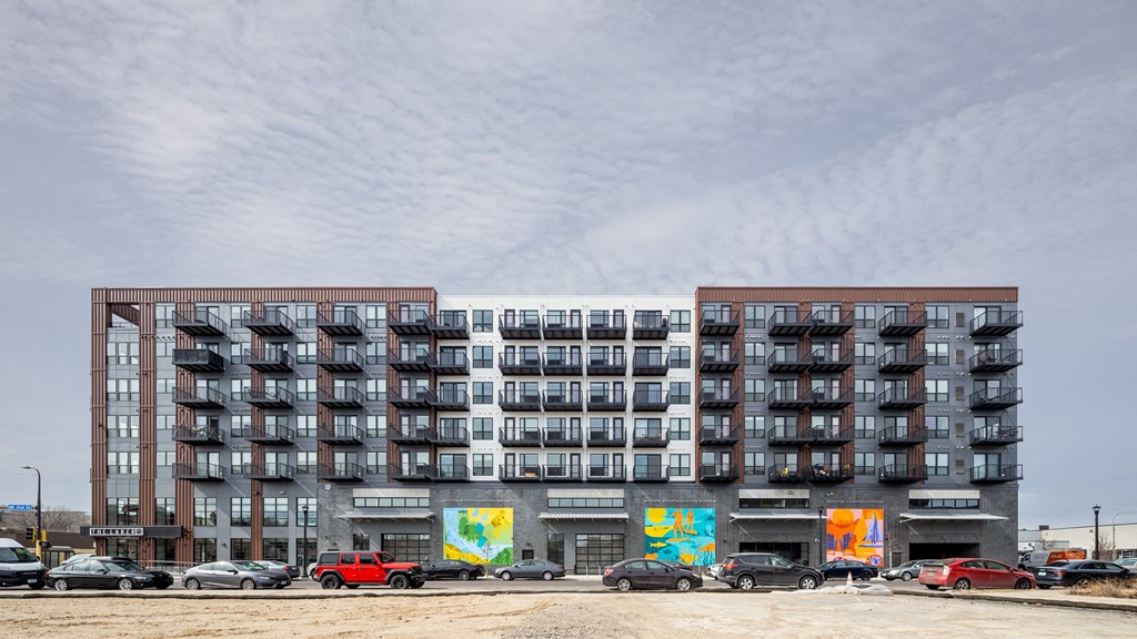 a large apartment building with cars parked in front of it