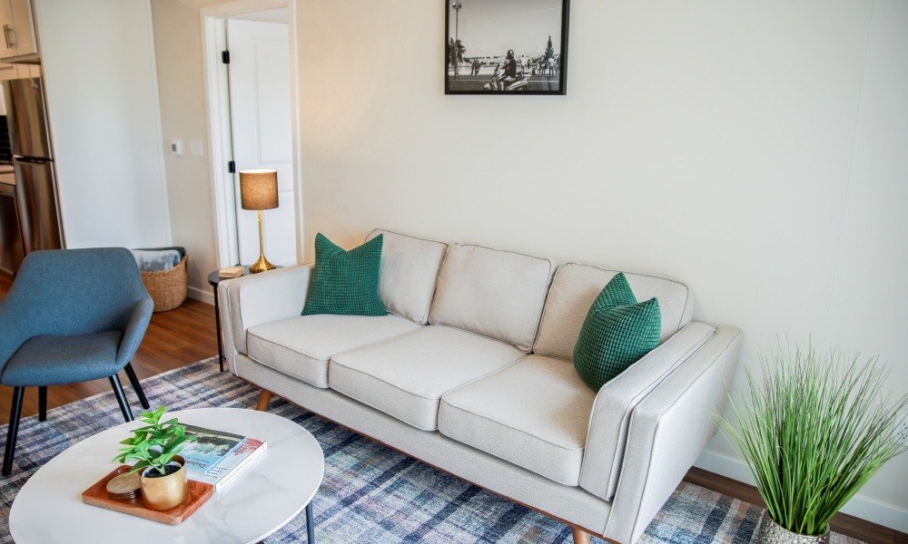 A living room with a white couch and a blue chair.
