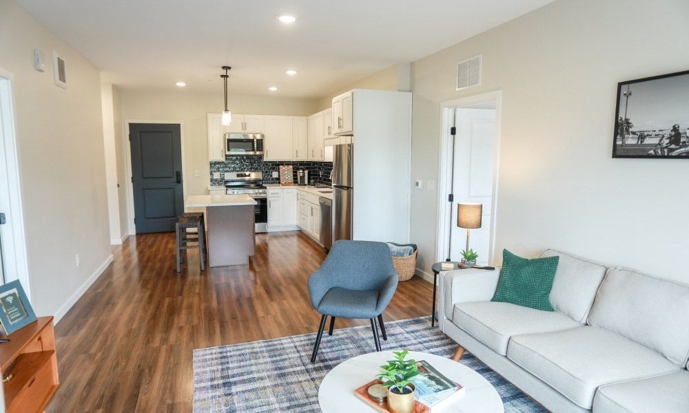 A modern living room with a white couch and a grey chair.