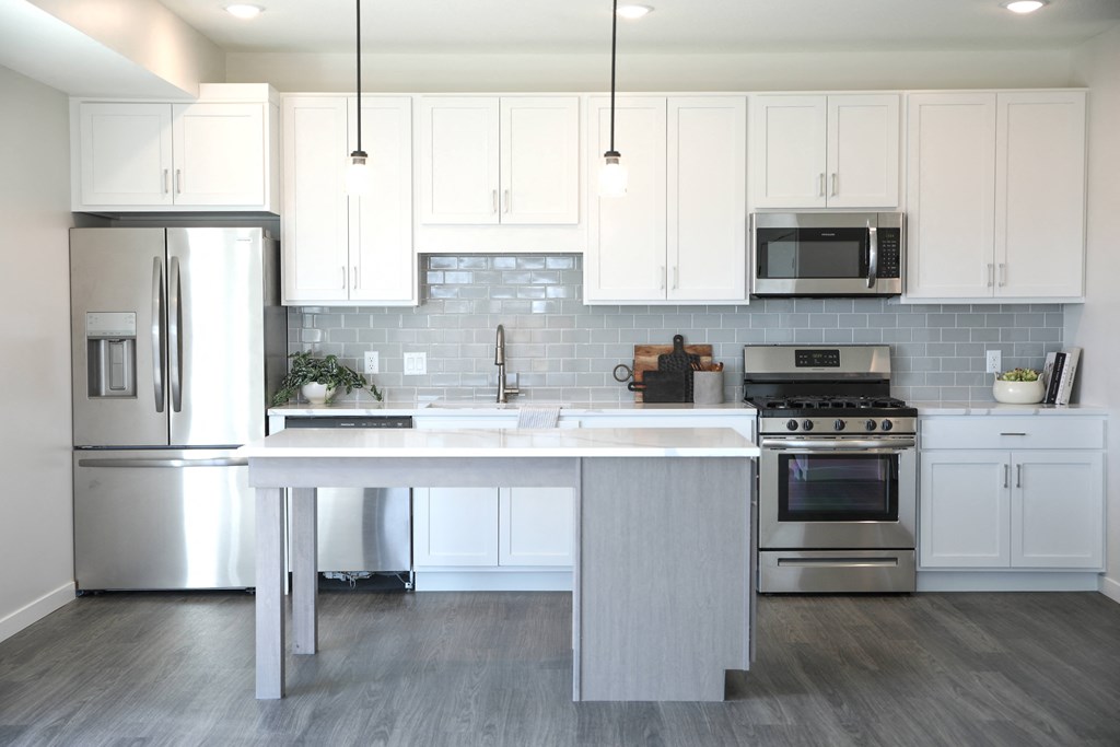 a kitchen with white cabinets and stainless steel appliances