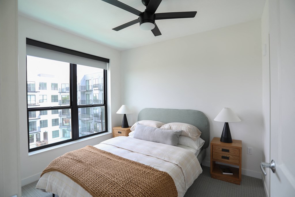 a bedroom with a bed and a ceiling fan