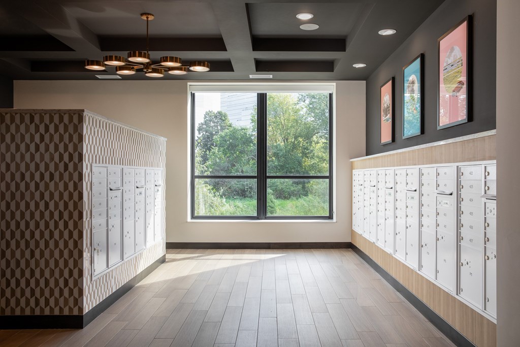 A hallway with a patterned wall and a window showing trees outside.