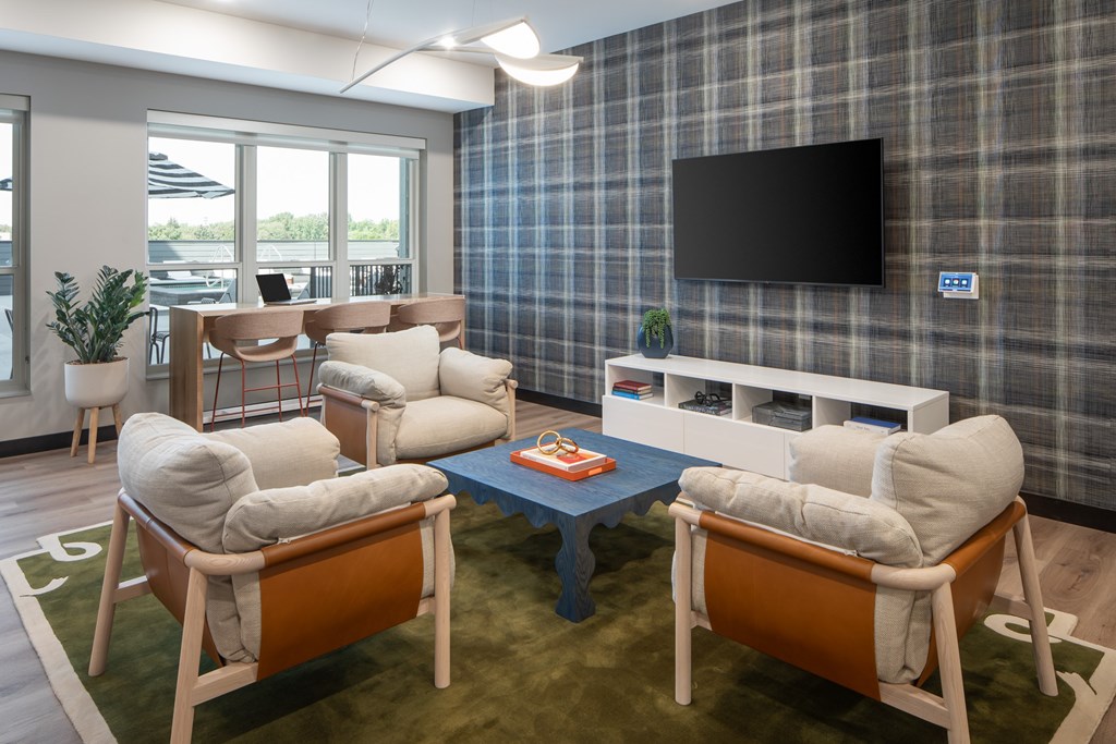 A room with a plaid wallpaper and a flat screen TV mounted on it.