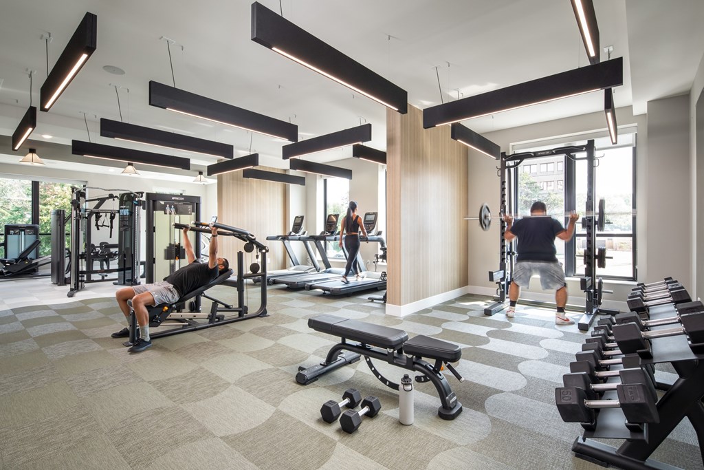 A man is working out in a gym with a variety of equipment.
