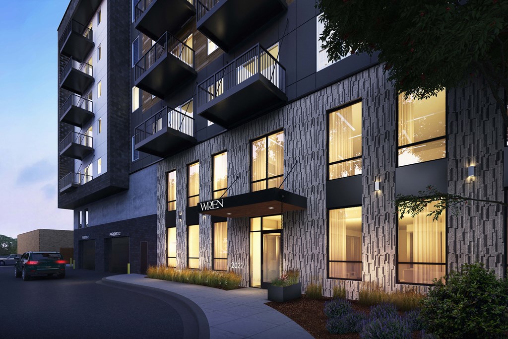 a rendering of an apartment building at night with its windows lit up