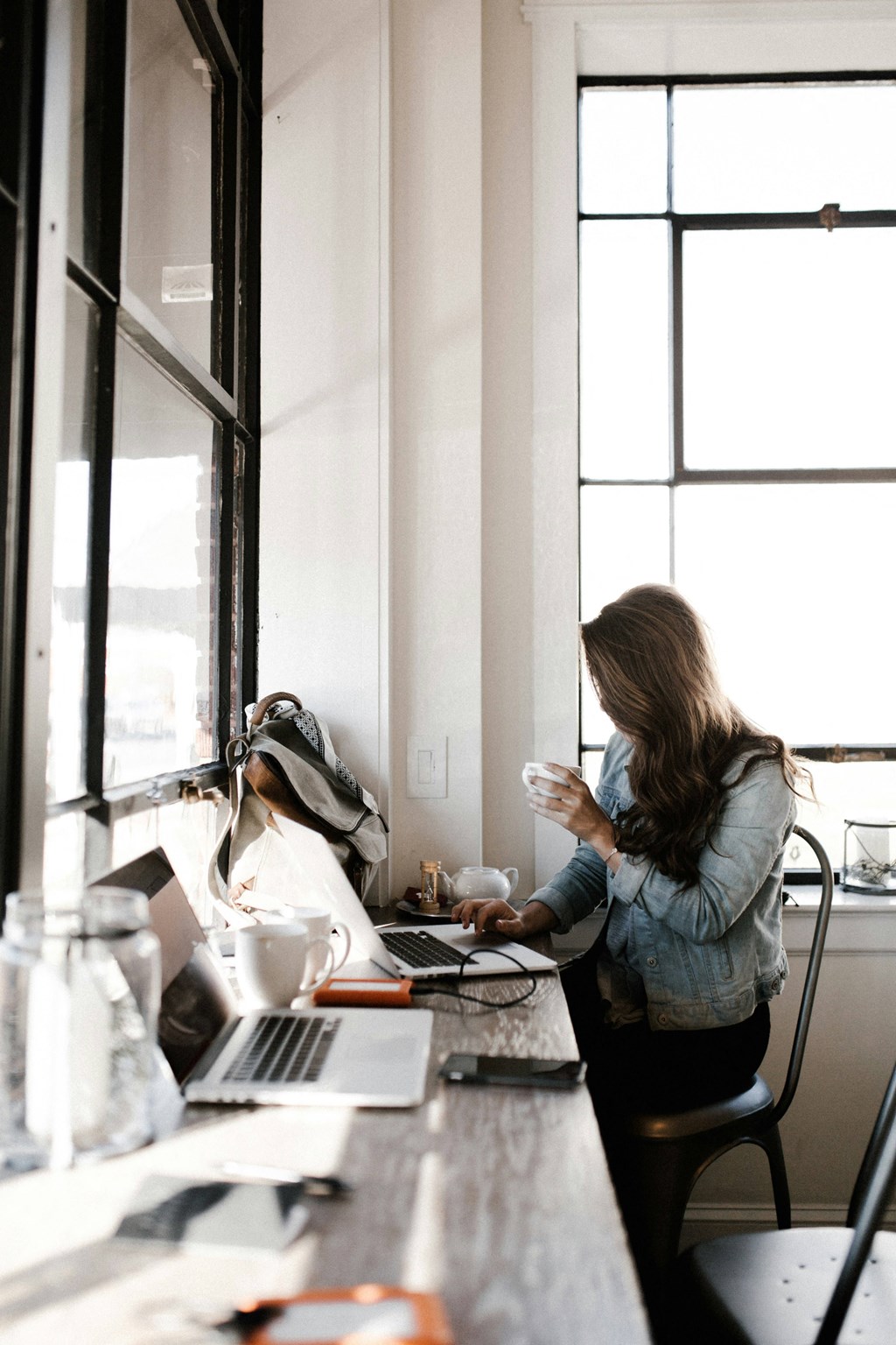 a woman sitting at a desk in front of a laptop computer