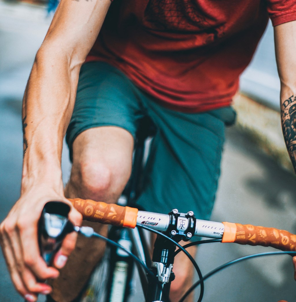 a man riding a bike with an orange handlebar