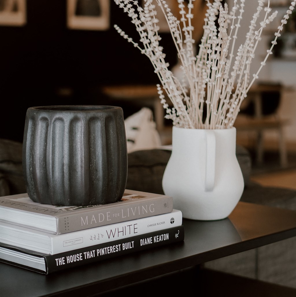 a vase with flowers on top of a stack of books on a table