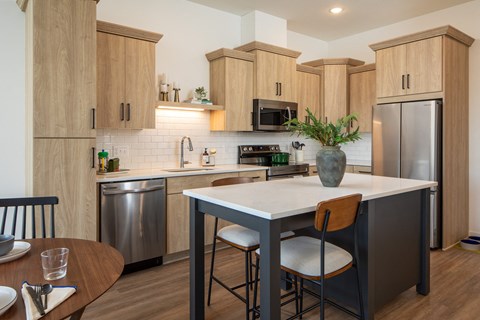 a kitchen with wooden cabinets and stainless steel appliances and a white counter top