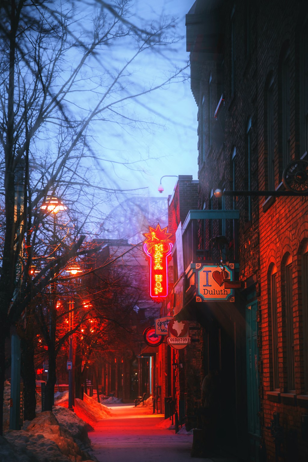 a city street at night with a neon sign on a building