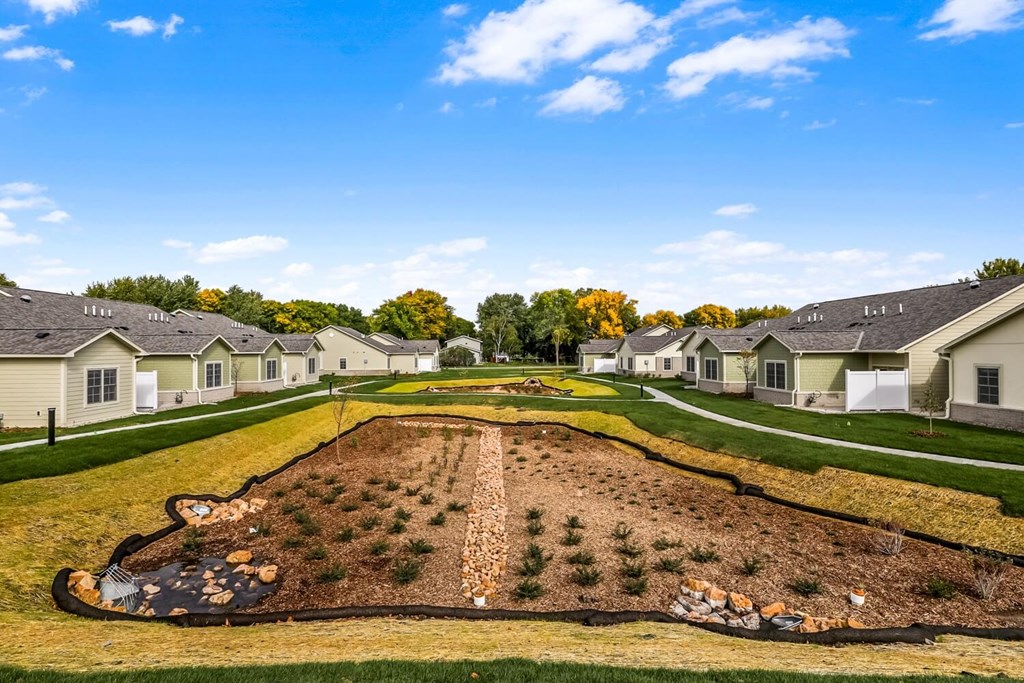 an aerial view of a neighborhood with houses and a dirt field