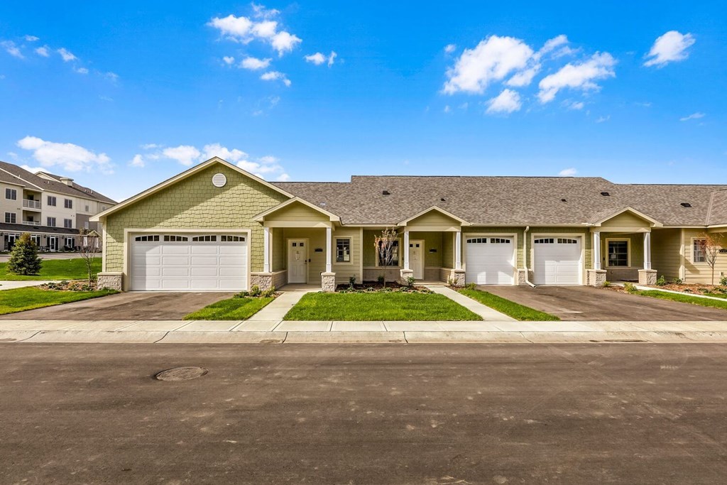 a house with two garage doors and a street in front of it