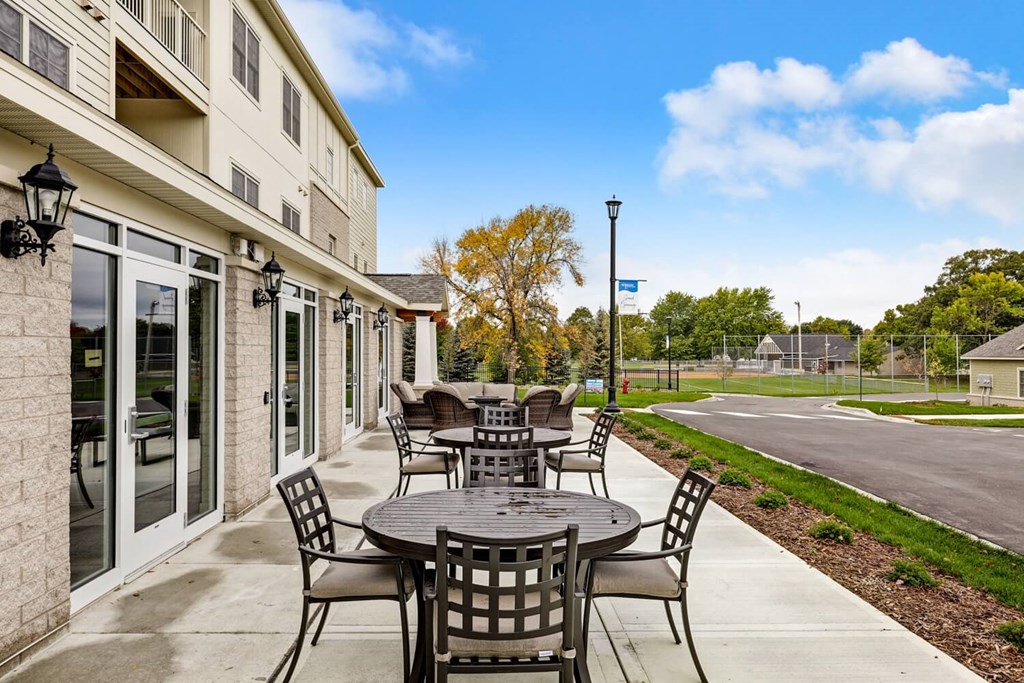 a patio with tables and chairs outside of a building
