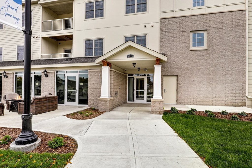 a walkway in front of a brick building with glass doors