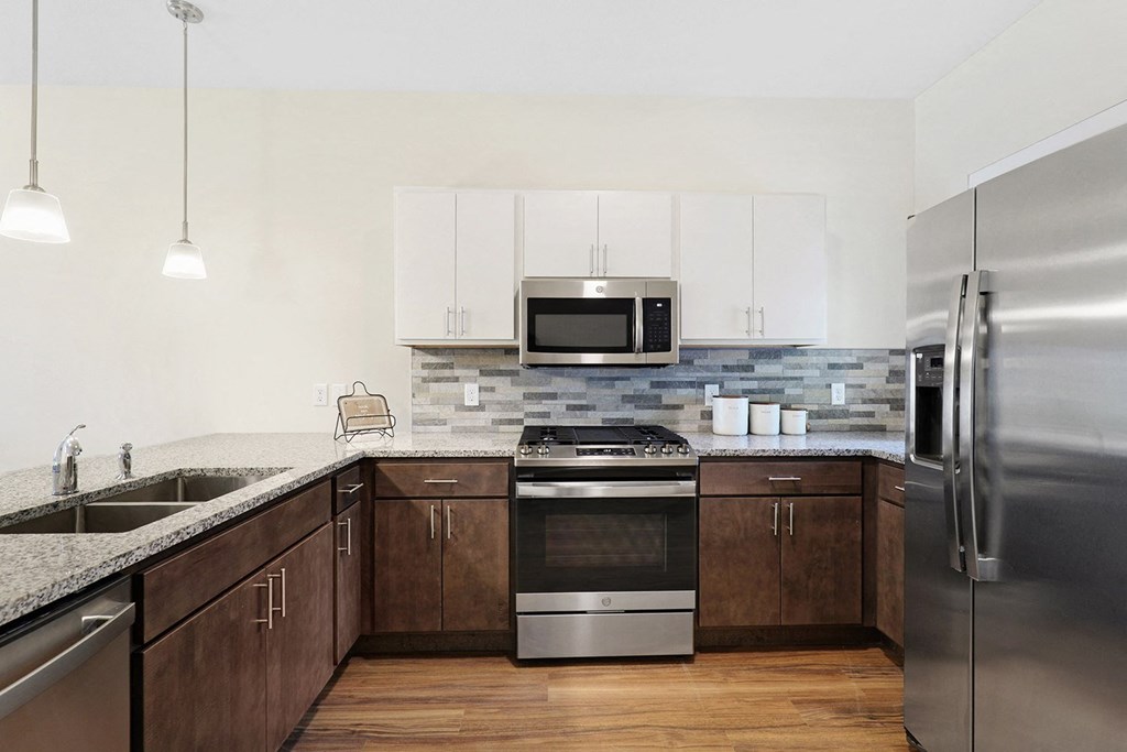 a modern kitchen with stainless steel appliances and white cabinets