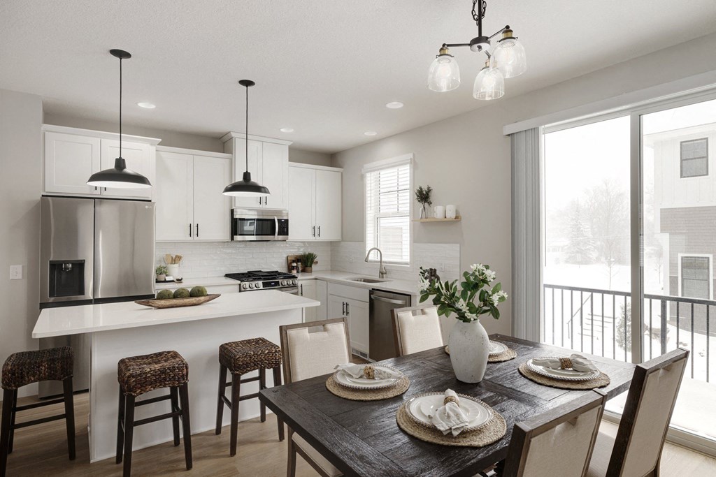 A modern kitchen with a dining table set for two.