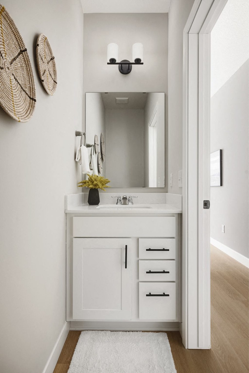 A bathroom with a white sink and a mirror above it.