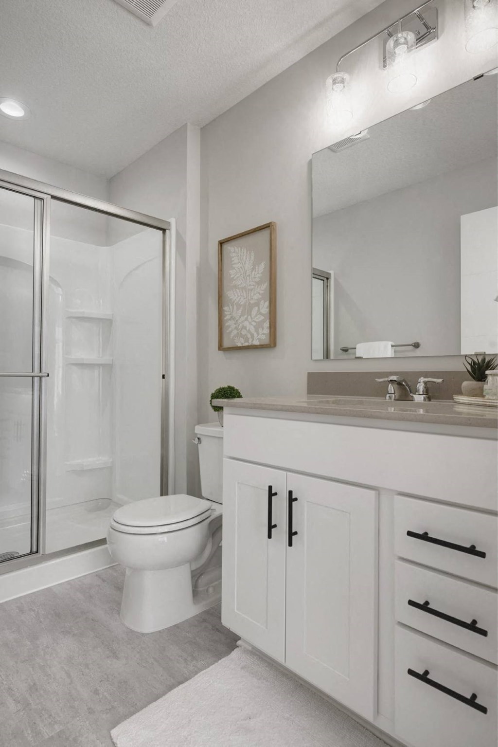 A white bathroom with a toilet, sink, and a mirror.