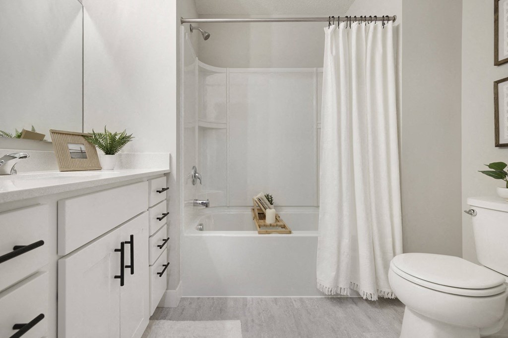 A white bathroom with a toilet, sink, and bathtub.