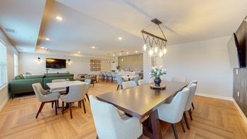 A modern dining room with a large table and chairs.