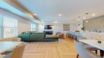 A modern living room with a green sofa and a wooden floor.