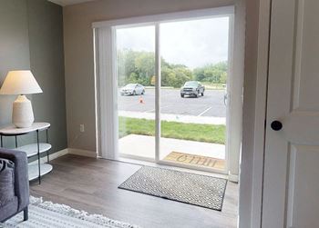 A room with a sliding glass door leading to a parking lot.