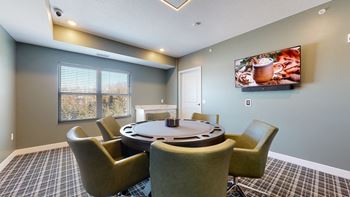 A room with a table and chairs and a picture of food on the wall.