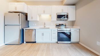 A kitchen with white cabinets and appliances.