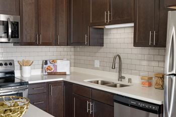 A kitchen with brown cabinets and a white counter.