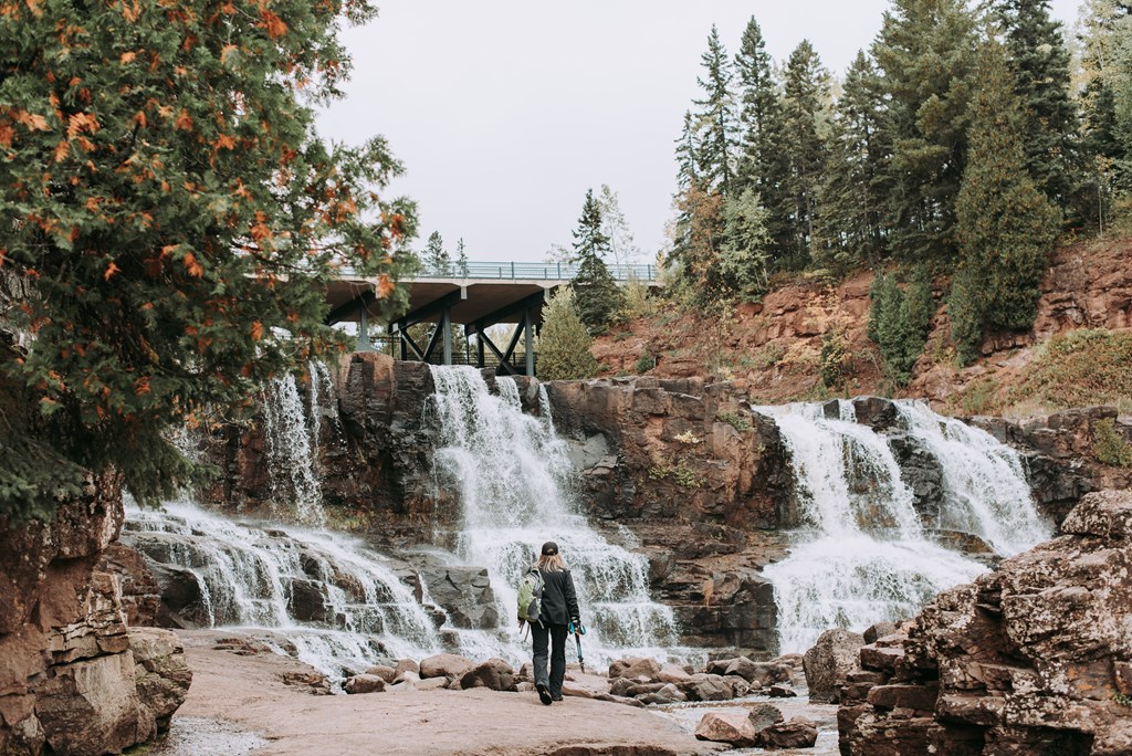 a man standing in front of a waterfall