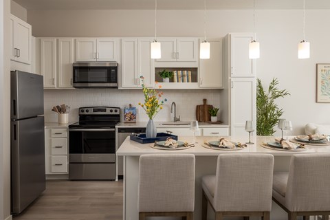 A modern kitchen with a kitchen island set for three..