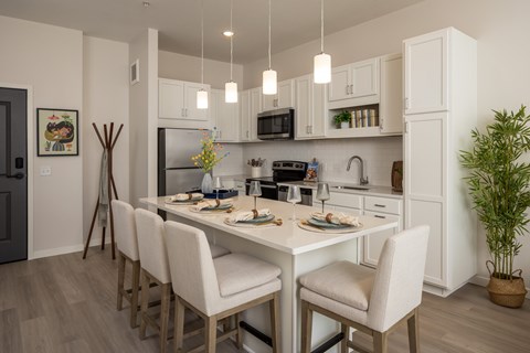 A modern kitchen with a dining table set for four.