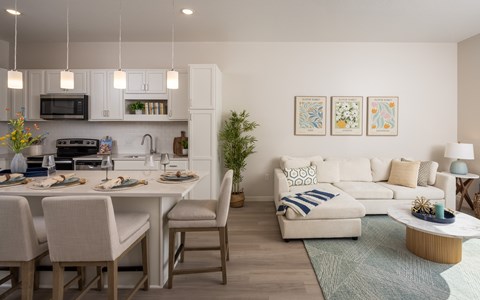 A modern kitchen with an island and chairs.