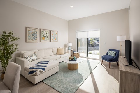 A living room with a white couch and a blue chair.