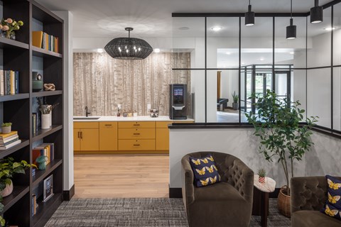 A modern living room with a brown sofa and a bookshelf filled with books.