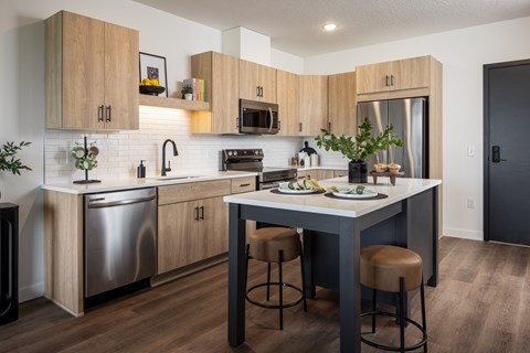 A modern kitchen with wooden cabinets and stainless steel appliances.