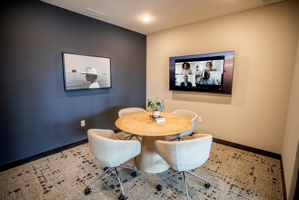 a dining room with a table and chairs and a television on the wall