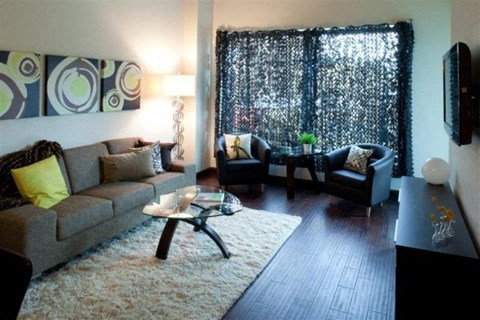 A living room with a grey couch, a coffee table, and a black chair.