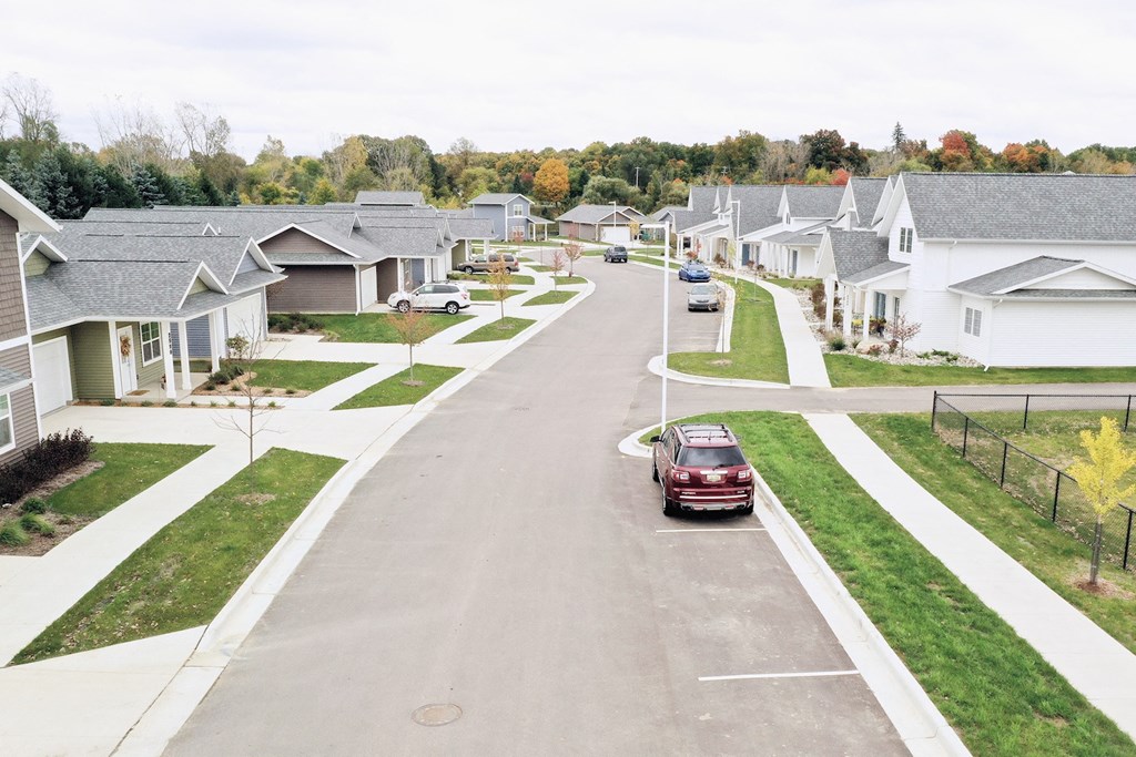 a car driving down a street in a suburban neighbourhood