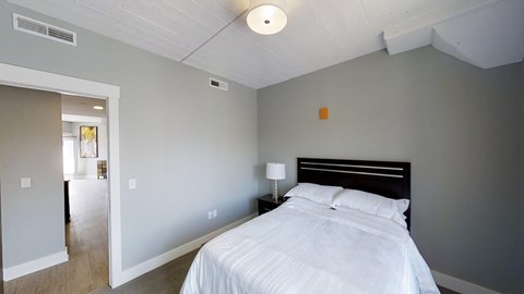a bedroom with a bed and a door to a bathroom
