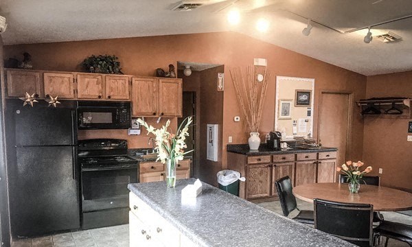a kitchen with black appliances and a table